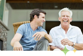 Father and son enjoying conversation about the benefits of taking Axona for people with mild to moderate Alzheimer's disease.